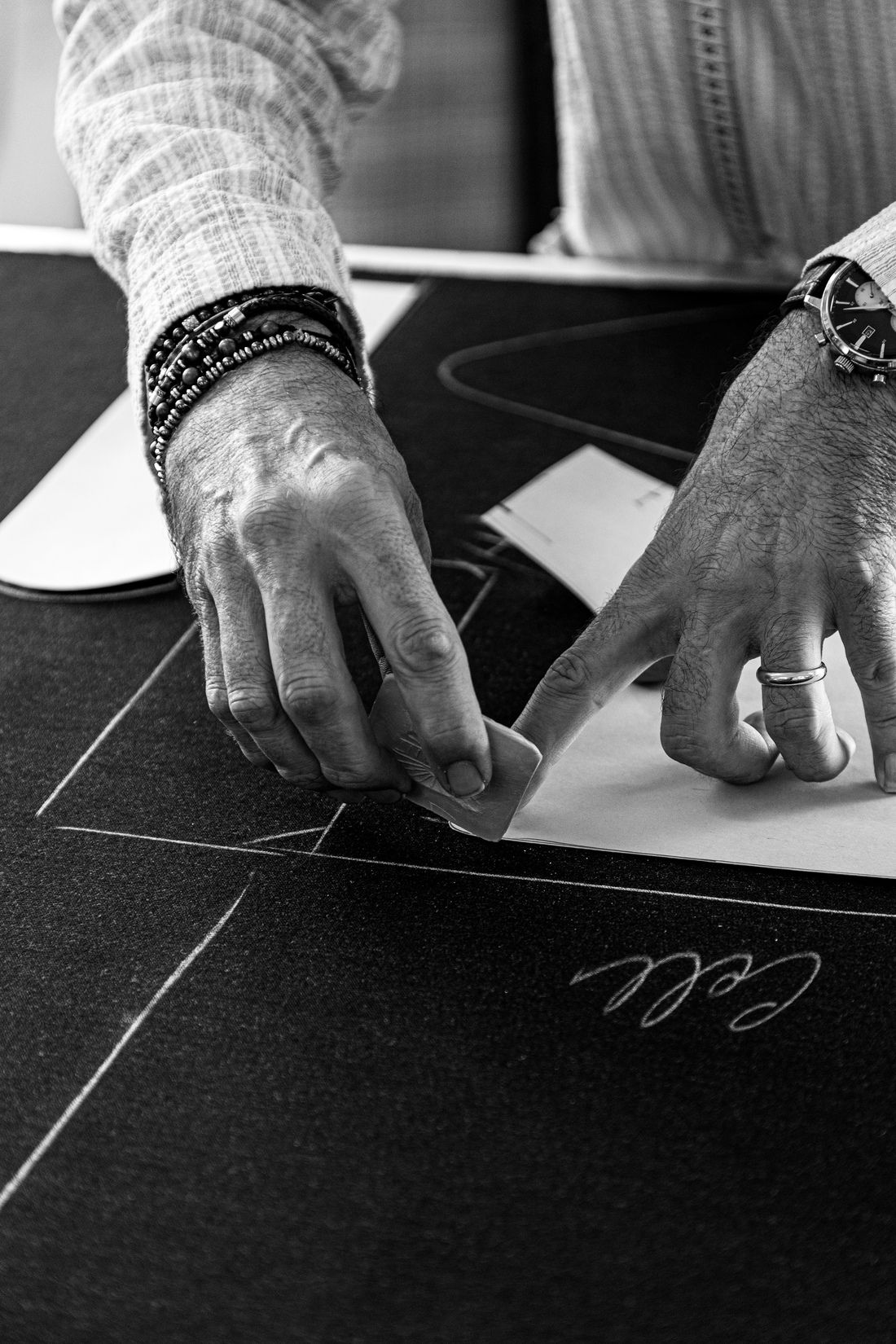 close-up of an atelier's hand at work making a mark on their workbench
