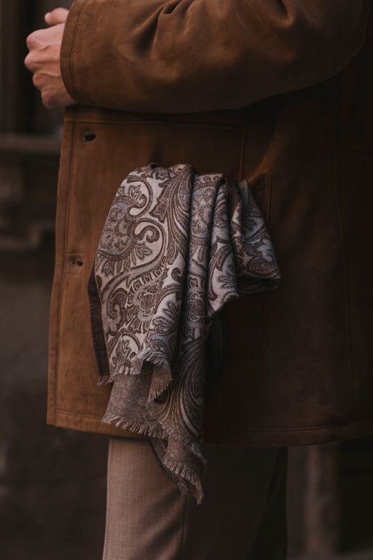 close-up of a scarve hanging out of a brown trenchcoat pocket