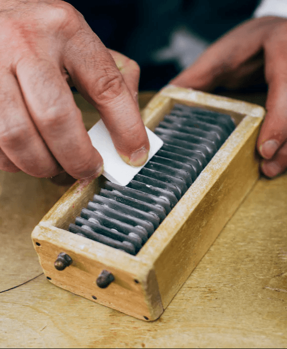Close-up of hands working away at a vintage tailor chalk-sharpener