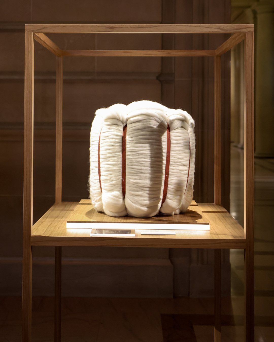 A stack of Vicuna wool in an enclosed wooden/glass box on display